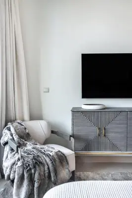 a living room with a chair and a flat screen tv at The Smart Concierge - Burjvista in Dubai