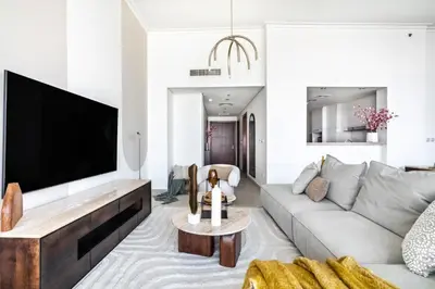 a living room with a couch and a flat screen tv at The Smart Concierge - Burjvista in Dubai