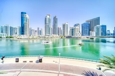 a city with tall buildings and a river with boats at Fairfield Tower, Park Island, Dubai Marina - Mint Stay in Dubai
