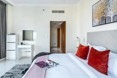 a bedroom with a large white bed with red pillows at The Smart Concierge - Marinascape Oceanic in Dubai