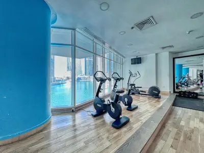a gym with treadmills and exercise bikes in a building at The Smart Concierge - Marinascape Oceanic in Dubai