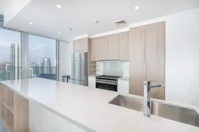 a kitchen with white counter tops and a large window at Luxurious 3BR Apartment with Panoramic Marina View in Dubai