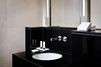 a black bathroom with a sink and a mirror at Emaar Dubai Mall Residences - formerly Address Dubai Mall Residences - Burj Khalifa View in Dubai