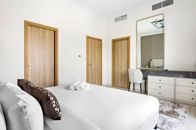 a bedroom with a white bed and a mirror at Luxurious 3BR Villa Amaranta in Dubai