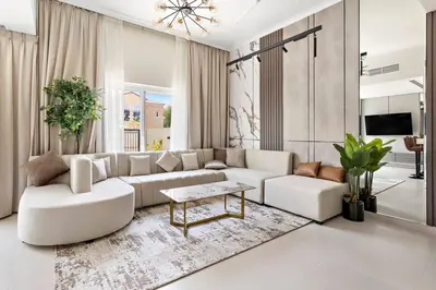 a living room with a white couch and a table at Luxurious 3BR Villa Amaranta in Dubai