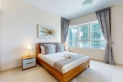 a bedroom with a bed and a large window at V3 Tower - Elegant One Bedroom in Dubai