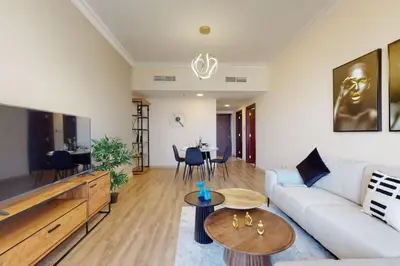 a living room with a couch and a tv at V3 Tower - Elegant One Bedroom in Dubai