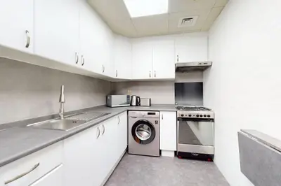 a kitchen with a washing machine and a sink at V3 Tower - Elegant One Bedroom in Dubai