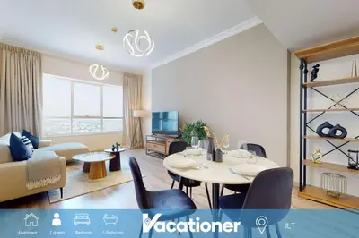 a living room with a table and a couch at V3 Tower - Elegant One Bedroom in Dubai