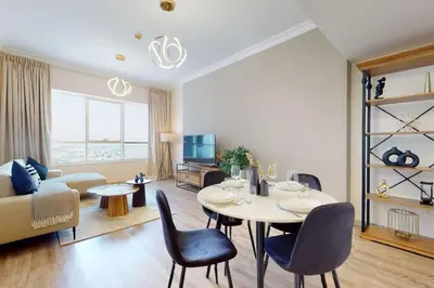 a living room with a table and chairs and a couch at V3 Tower - Elegant One Bedroom in Dubai