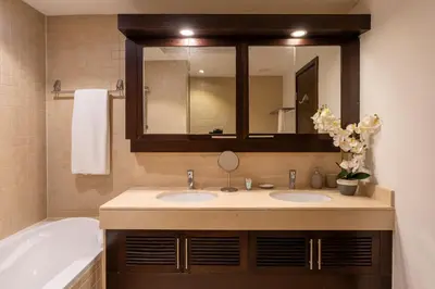 a bathroom with two sinks and a tub and a mirror at INA Homes-Tower 5 Perfect Burj Khalifa and Fountain Views in Dubai