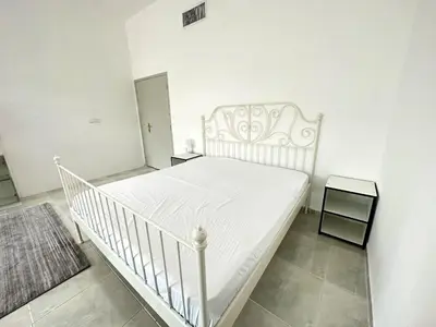 a white bed in a white room with a white crib at Nice Rooms for Rent in Compound Housing near Burj Alarab Dubai Villa 125 in Dubai