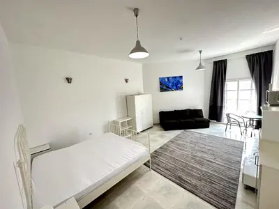 a living room with a white bed and a couch at Nice Rooms for Rent in Compound Housing near Burj Alarab Dubai Villa 125 in Dubai