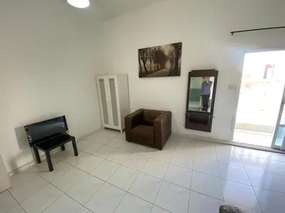 a living room with a chair and a mirror at Nice Rooms for Rent in Compound Housing near Burj Alarab Dubai Villa 125 in Dubai