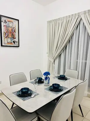 a dining room table with chairs and a white table and chairsktop at INA Homes-BLVD Central 2BHK Apartment near Burj Khalifa in Dubai