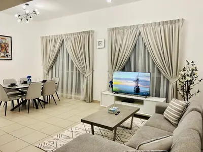 a living room with a couch and a television and a table at INA Homes-BLVD Central 2BHK Apartment near Burj Khalifa in Dubai
