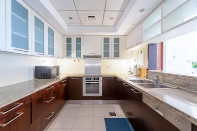 a large kitchen with wooden cabinets and a large window at INA Homes-BLVD Central 2BHK Apartment near Burj Khalifa in Dubai