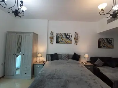a bedroom with a large bed and a couch at Diamond 2 Tower Marina Apartment in Dubai