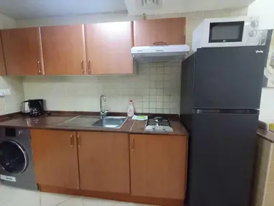 a kitchen with a sink and a black refrigerator at Diamond 2 Tower Marina Apartment in Dubai