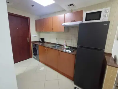a kitchen with a black refrigerator and a sink at Diamond 2 Tower Marina Apartment in Dubai