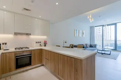 a kitchen with a counter top and a living room at Sleek 1 Bedroom with Views of Dubai Marina in Dubai