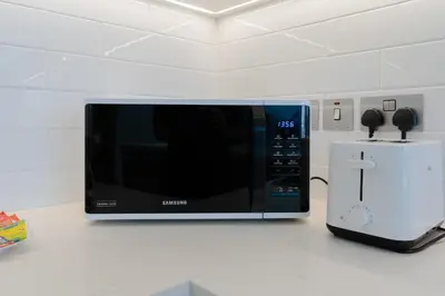 a microwave sitting on top of a counter next to a food processor at Sleek 1 Bedroom with Views of Dubai Marina in Dubai