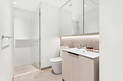 a white bathroom with a toilet and a sink at Silkhaus modern 1BDR in Belgravia Heights with pool & gym in Dubai