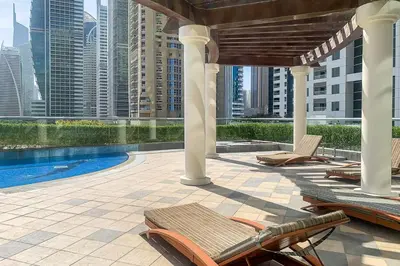 a patio with chairs and a pool on a building at Frank Porter - MAG214 in Dubai
