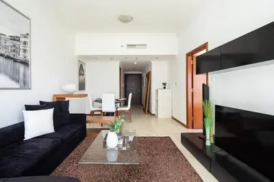 a living room with a black couch and a table at Frank Porter - MAG214 in Dubai