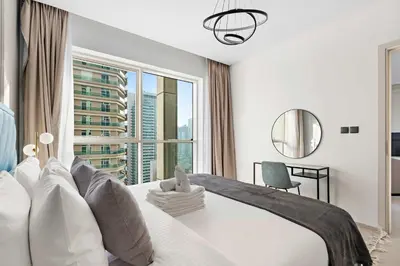 a bedroom with a large bed with a large window at Silkhaus chic 1BDR in west avenue with Pool & gym access in Dubai