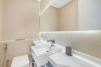 a white bathroom with a sink and a toilet at Silkhaus chic 1BDR in west avenue with Pool & gym access in Dubai