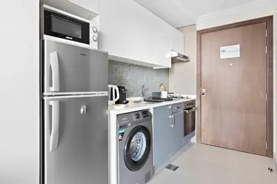 a kitchen with a washing machine and a washer at Silkhaus spacious studio in Art Gardens with gym & pool access in Dubai