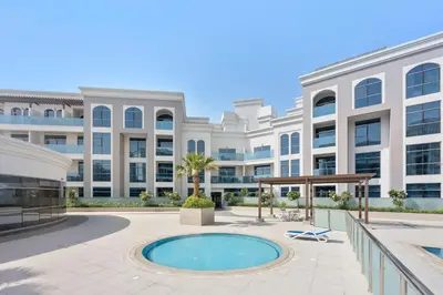 an exterior view of a large building with a pool at Silkhaus spacious studio in Art Gardens with gym & pool access in Dubai