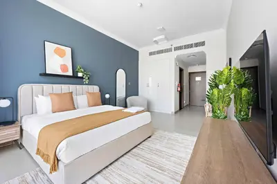a bedroom with a large bed and blue walls at Silkhaus beautiful studio in Art Gardens with pool access in Dubai