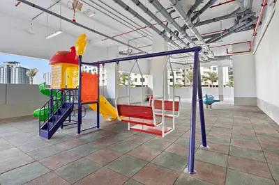 a play room with a slide and swings at Silkhaus beautiful studio in Art Gardens with pool access in Dubai