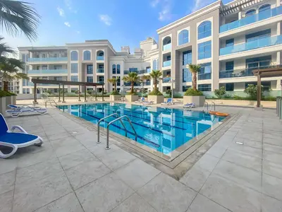 a swimming pool in front of a building at Silkhaus new studio in Art Gardens pool access in Dubai