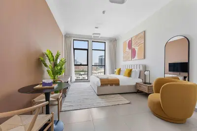 a bedroom with a bed and a living room at Silkhaus exquisite studio in Art Gardens with gym access in Dubai
