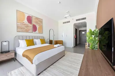 a bedroom with a bed and a flat screen tv at Silkhaus exquisite studio in Art Gardens with gym access in Dubai