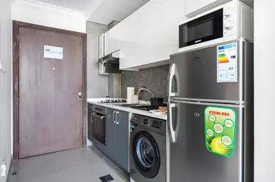 a kitchen with a stainless steel refrigerator and a dishwasher at Silkhaus exquisite studio in Art Gardens with gym access in Dubai