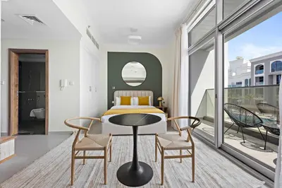 a bedroom with a bed and two chairs and a table at Silkhaus Modern Studio with New Furniture in Dubai