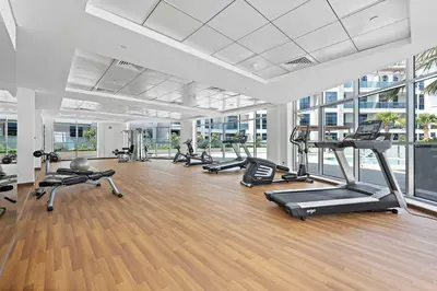 a gym with several treadmills and elliptical machines at Silkhaus Modern Studio with New Furniture in Dubai