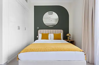 a bedroom with a large bed and a mirror at Silkhaus Modern Studio with New Furniture in Dubai