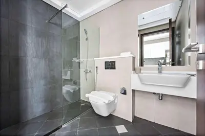 a bathroom with a toilet and a sink and a shower at Silkhaus Chic Studio in Art Gardens Modern Living in Dubai