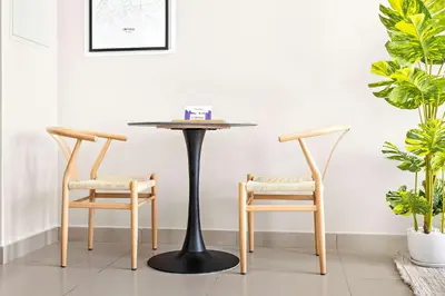 a table and two chairs in a living room at Silkhaus furnished studio in Art Gardens with pool access in Dubai