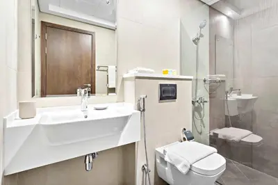 a bathroom with a sink and a toilet and a shower at Silkhaus furnished studio in Art Gardens with pool access in Dubai