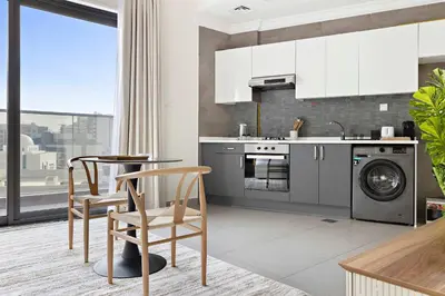 a kitchen with a washing machine and a dishwasher at Silkhaus aesthetic studio in Art Gardens with gym & pool access in Dubai