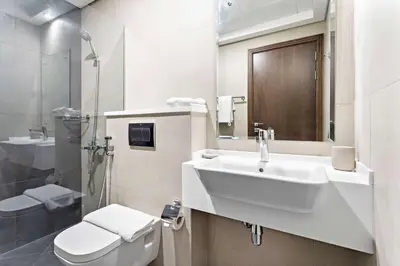 a white bathroom with a sink and a toilet at Silkhaus aesthetic studio in Art Gardens with gym & pool access in Dubai