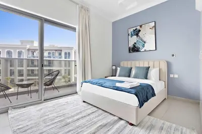 a bedroom with a bed and a large window at Silkhaus luxurious studio in Art Gardens with gym access in Dubai