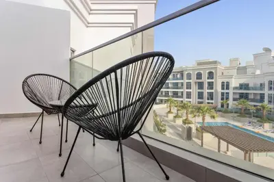 two chairs on a balcony with a view of a building at Silkhaus luxurious studio in Art Gardens with gym access in Dubai