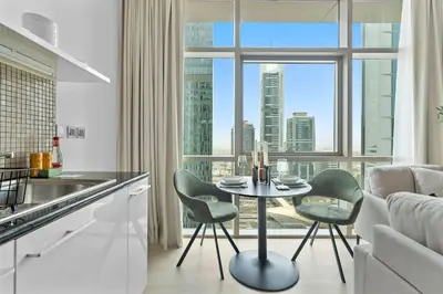 a kitchen with a table and chairs in front of a window at Silkhaus modern studio in Liberty House in Dubai